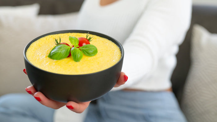 Frau mit Schüssel Instant Maize Pudding in der Hand